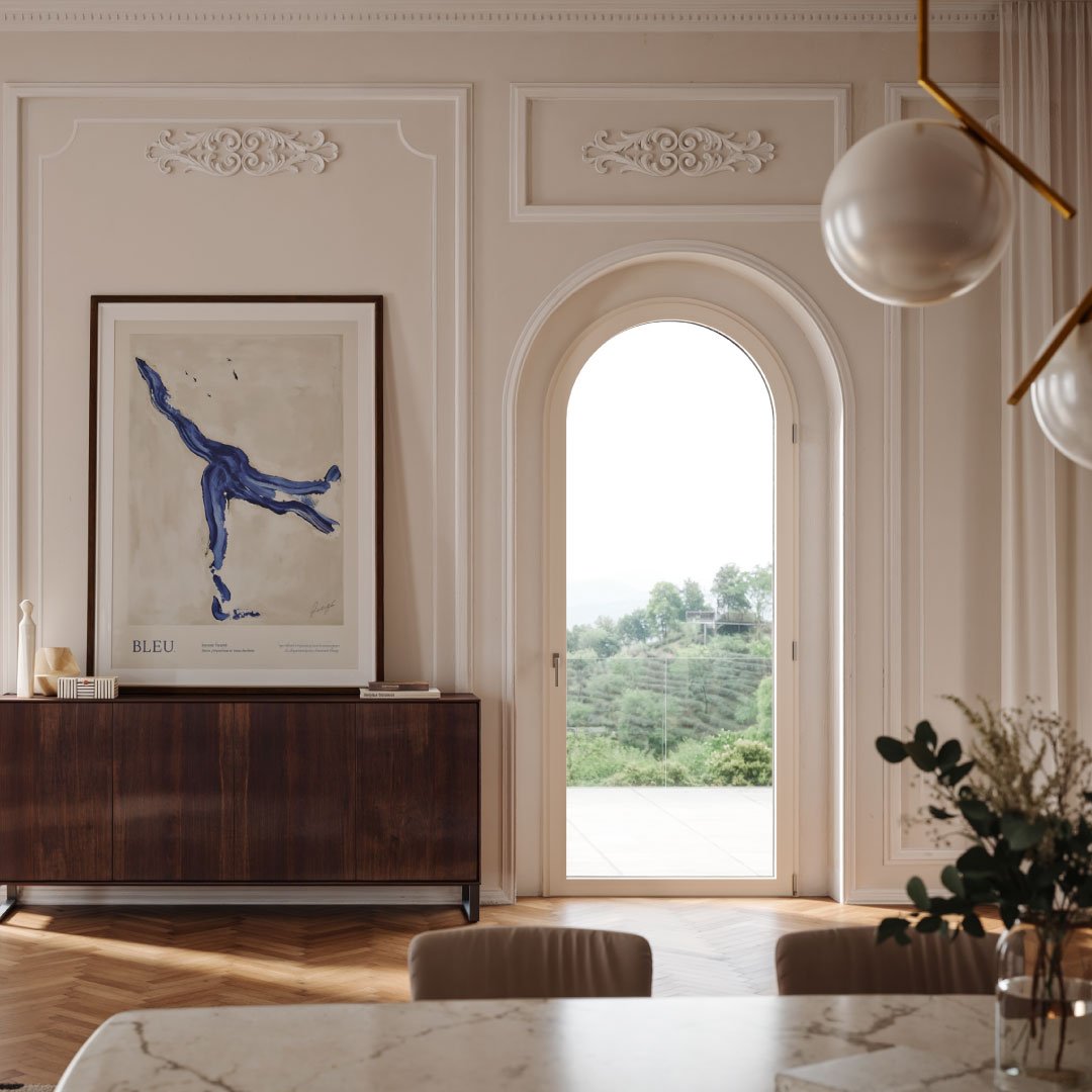 Interno elegante con una porta ad arco, un quadro moderno e vista su colline verdi.